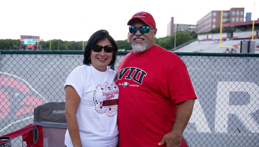 UIW parents in front of a chainlink fence